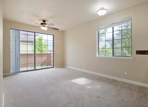 A room with a ceiling fan and a window with a view of trees at Siena Villas Apartments, Orem, Utah