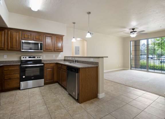 A kitchen with brown cabinets and a black refrigerator. at Siena Villas Apartments, Apartments, Orem, UT