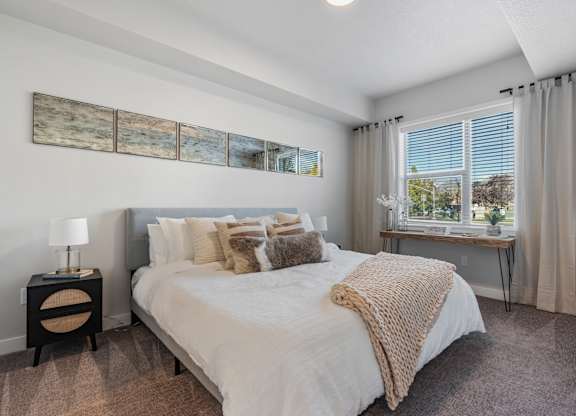 a bedroom with a large bed and a window at The Flats at Riverwoods, Provo, UT, 84604