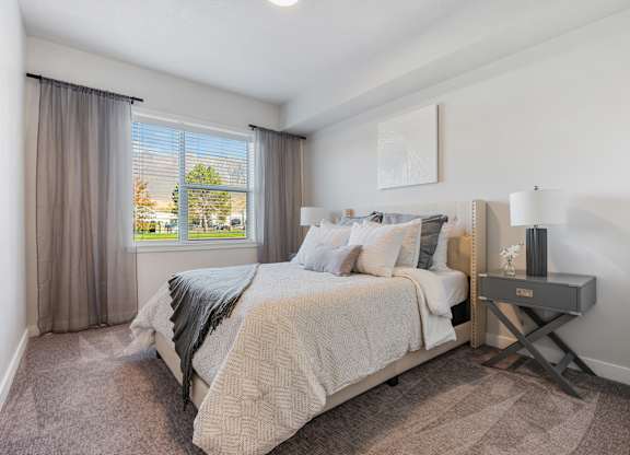 a bedroom with a bed and a window at The Flats at Riverwoods, Provo, UT, 84604