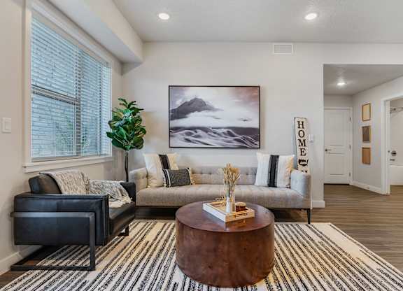 a living room with a couch and a coffee table at The Flats at Riverwoods, Provo, Utah