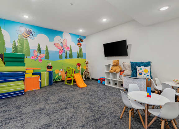 a play room with chairs and toys and a wall mural at The Flats at Riverwoods, Provo, UT