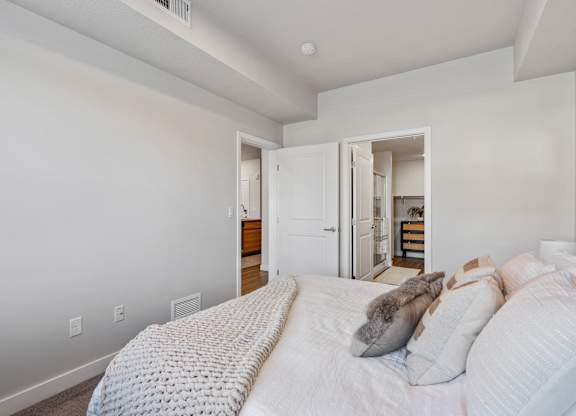 bedroom with a door to a bathroom at The Flats at Riverwoods, Provo