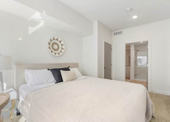 a bedroom with a large bed and a bathroom at Paperbox Lofts, Salt Lake City