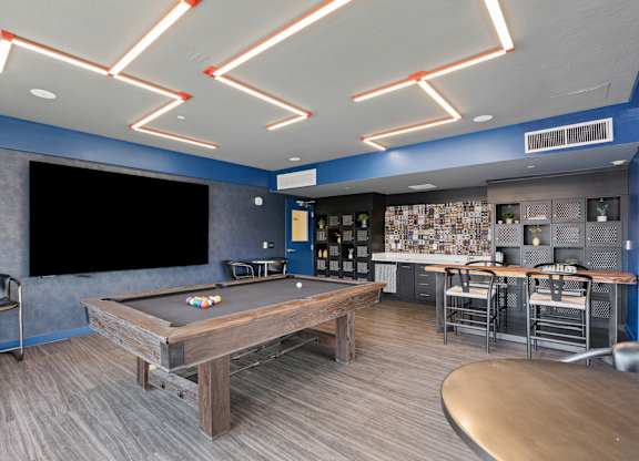 a game room with a pool table and a tv at Paperbox Lofts, Utah, 84101