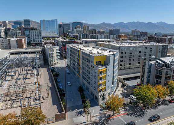 A cityscape with a large building in the foreground and mountains in the background.