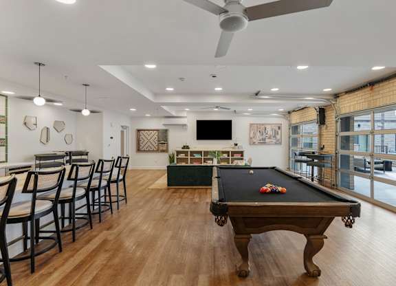 a game room with a pool table and a bar with chairs at The Revival, Salt Lake City, Utah
