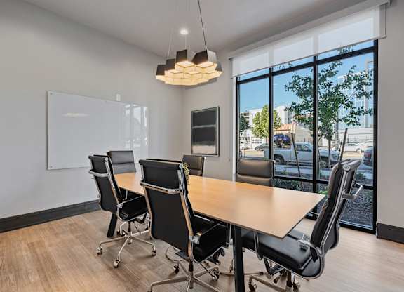 a conference room with a wooden table and chairs at SevenO2 Main Apartments, Salt Lake City, 84101