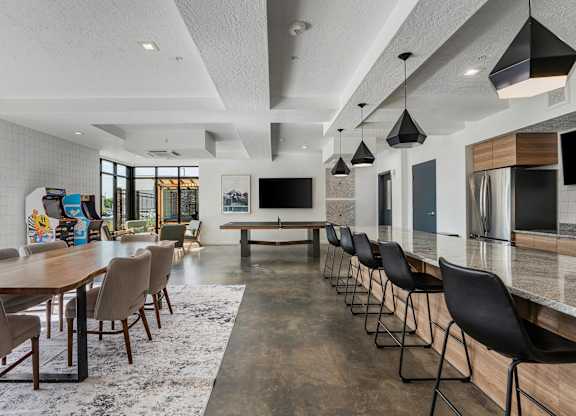 a large dining room with a long table and chairs and a kitchen and living room at The Flats at Riverwoods, Provo, UT, 84604