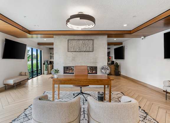 a living room with a fireplace and a table and chairs at The Flats at Riverwoods, Provo, 84604