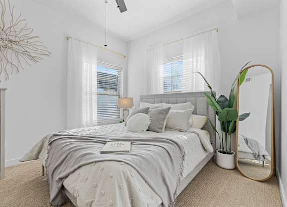 a white bedroom with a bed and a mirrorat The View on 20th, Ogden