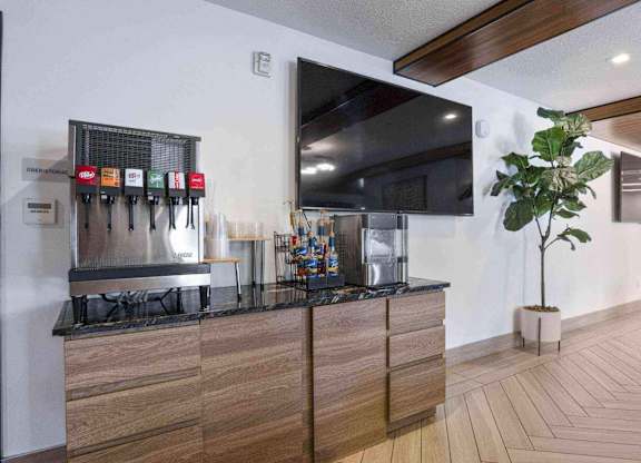 a large flat screen tv hangs above a kitchen countertop at The Flats at Riverwoods, Provo, UT, 84604
