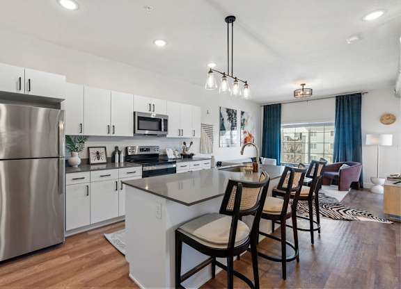 an open kitchen and dining area with a stainless steel refrigerator at The Revival, Salt Lake City
