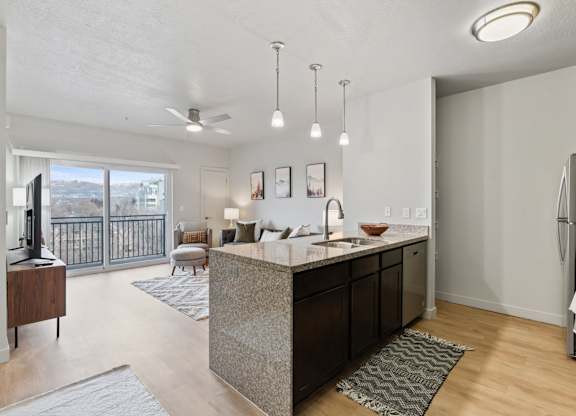 A modern kitchen with a large island and a view of the city. at Wilmington Flats Apartments, Salt Lake City