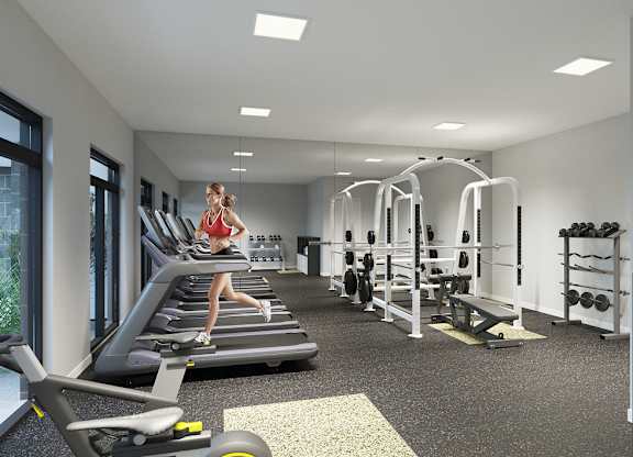 A woman is running on a treadmill in a well-equipped gym.