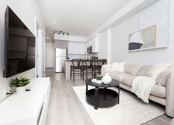 A modern living room with a grey sofa and a black coffee table.