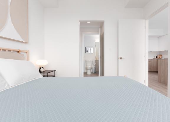A bedroom with a large bed and a mirror on the wall.
