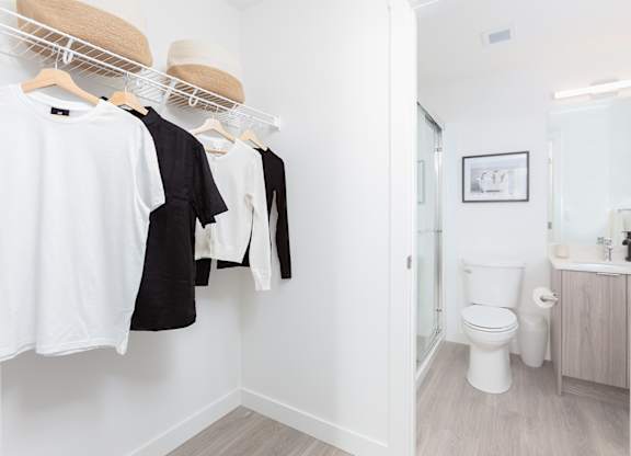 Clothes hanging on a rack in a white room.