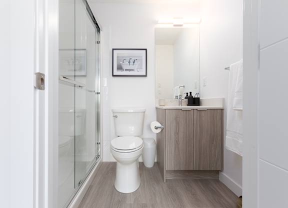 A white toilet sits in a bathroom next to a wooden cabinet.