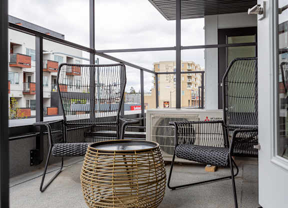 A balcony with a table and chairs.