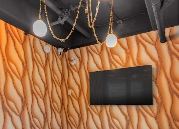 A table with four chairs in front of a wallpapered wall.