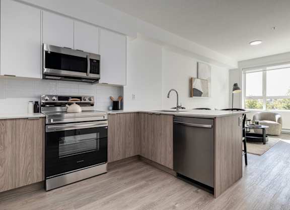 A modern kitchen with a large island and stainless steel appliances.