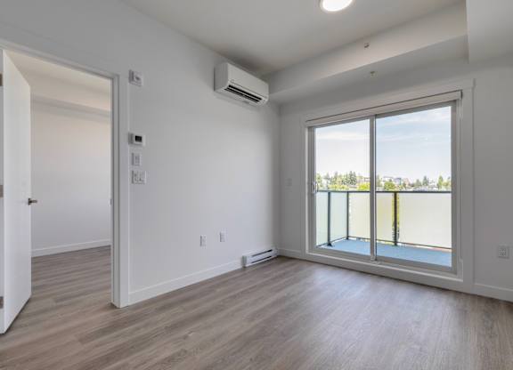 A room with a sliding glass door leading to a balcony.