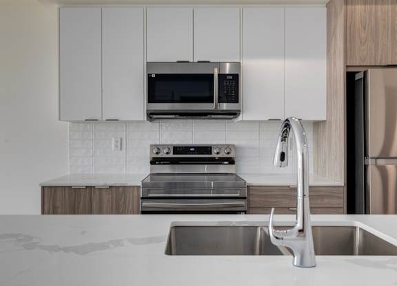 A modern kitchen with a stainless steel refrigerator and a white countertop.