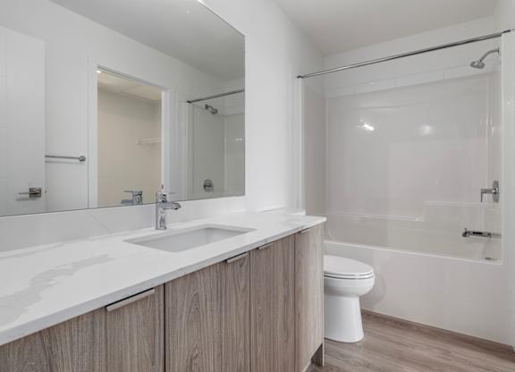 A white bathroom with a sink, toilet, and bathtub.
