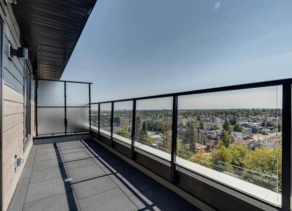 A balcony with a metal railing overlooks a cityscape.