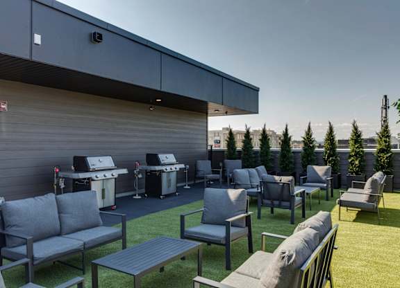 A patio area with grey couches and tables.