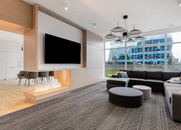 A modern living room with a large flat screen TV mounted on the wall.
