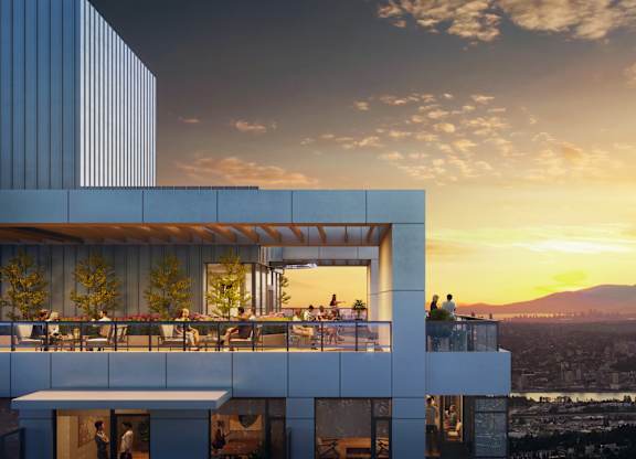 A modern building with a balcony overlooking a cityscape at sunset.
