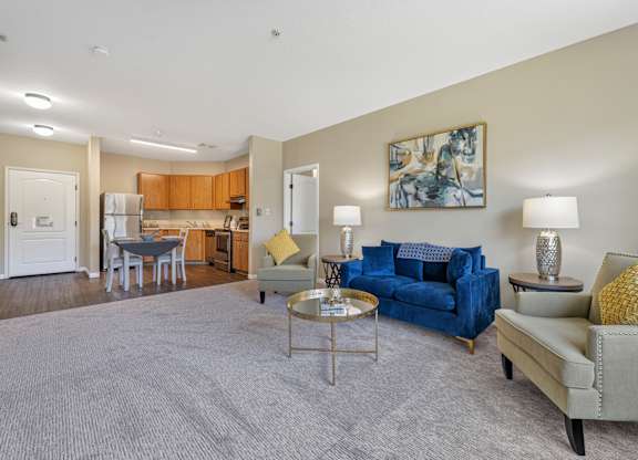 A living room with a blue couch and a grey rug.