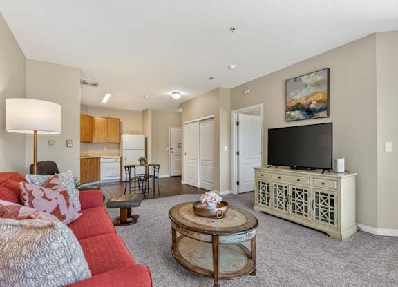 A living room with a red couch and a wooden coffee table.