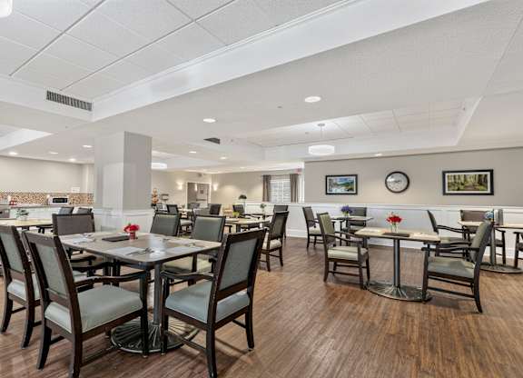 A restaurant with wooden floors and tables with chairs.