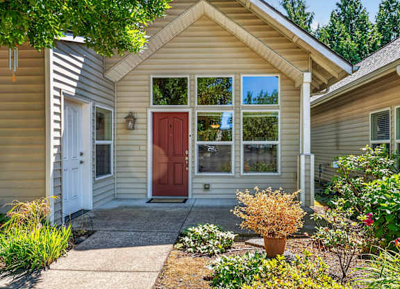 A house with a red door and a small front yard.