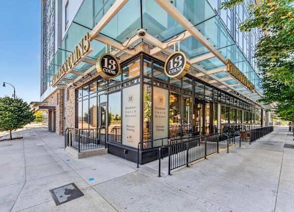 The exterior of a building with a glass facade and a sign that reads
