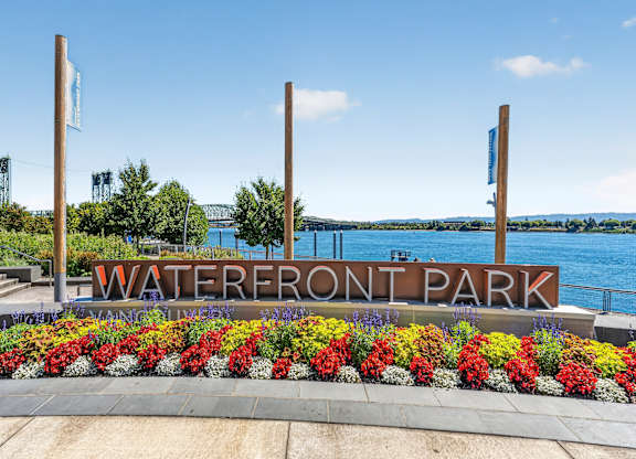 A sign that says Waterfront Park in front of a body of water.