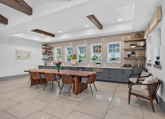 A kitchen with a table and chairs in front of a window.