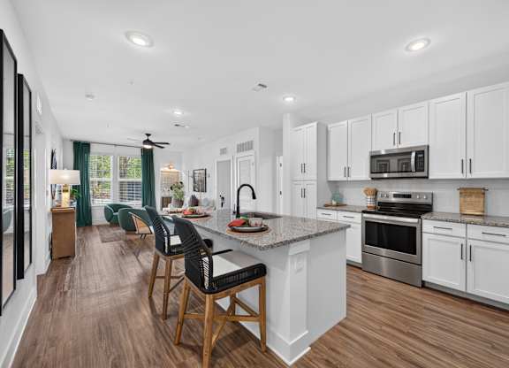 A modern kitchen with white cabinets and a center island.