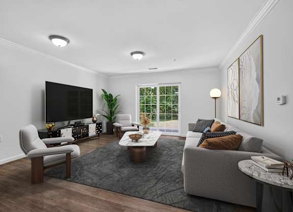 A modern living room with a grey couch, a coffee table, and a flat screen TV.