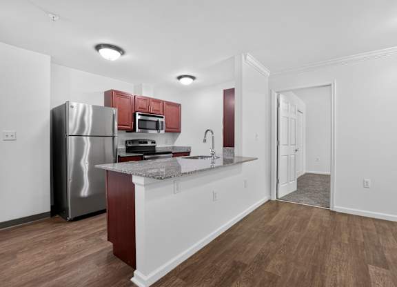 A kitchen with a refrigerator, microwave, and a countertop.