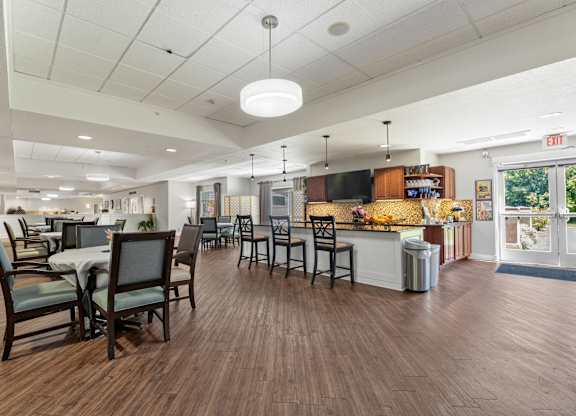 A large room with tables and chairs and a bar area.