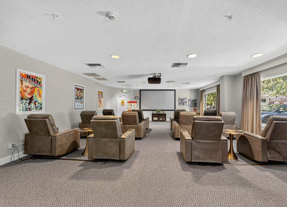 A room with grey carpet and brown chairs.