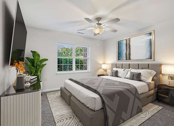 A bedroom with a large bed and a ceiling fan.