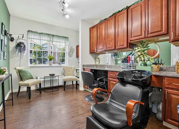 A kitchen with brown cabinets and a black chair.