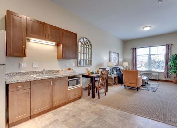 A kitchen with wooden cabinets and a dining table with chairs.