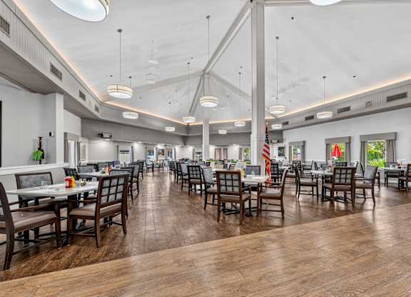 A restaurant with wooden tables and chairs and a white ceiling.