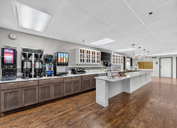 A modern kitchen with wooden floors and white countertops.